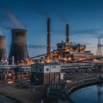 Power station with cooling towers and a sampling building at dusk